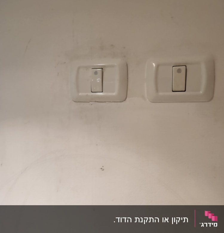 שני מתגים לבנים על קיר לבן